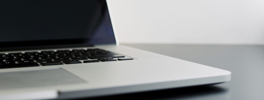 silver laptop computer on black table