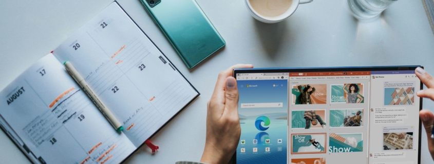 person using Windows 11 computer beside white ceramic mug on white table