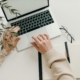 Free An overhead view of a person working on a laptop in a minimalist home office setting. Stock Photo