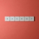 Free Close-up of keyboard keys spelling 'BACKUP' placed on a coral-colored surface. Stock Photo