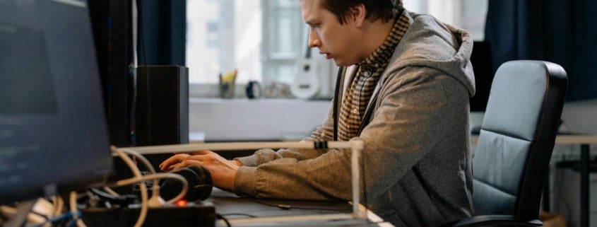 Free A concentrated professional working at a computer in a modern office setting. Stock Photo