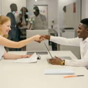 Free Business professionals completing a successful deal with a handshake in a modern office setting. Stock Photo