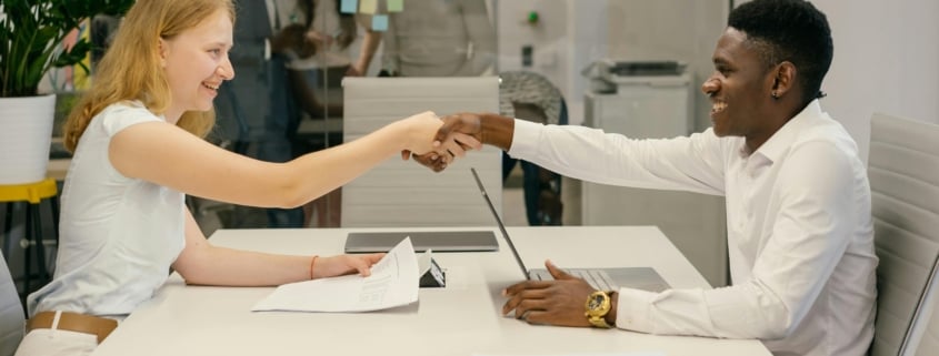 Free Business professionals completing a successful deal with a handshake in a modern office setting. Stock Photo